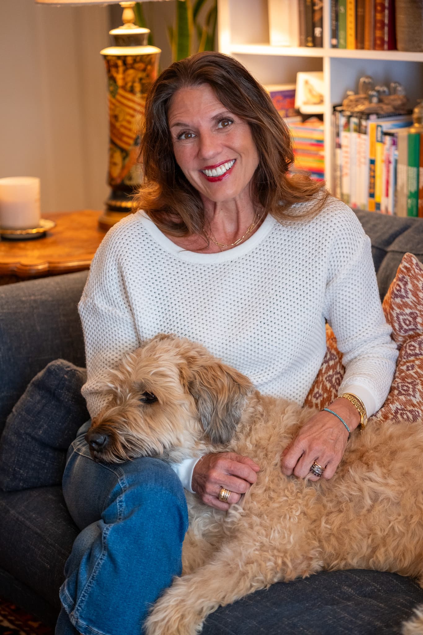 Leigh Christie at home, sitting on a sofa with her dog.